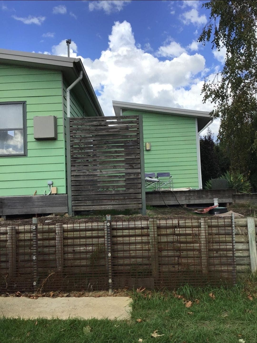 The same house before, with a weathered deck and a slatted screen