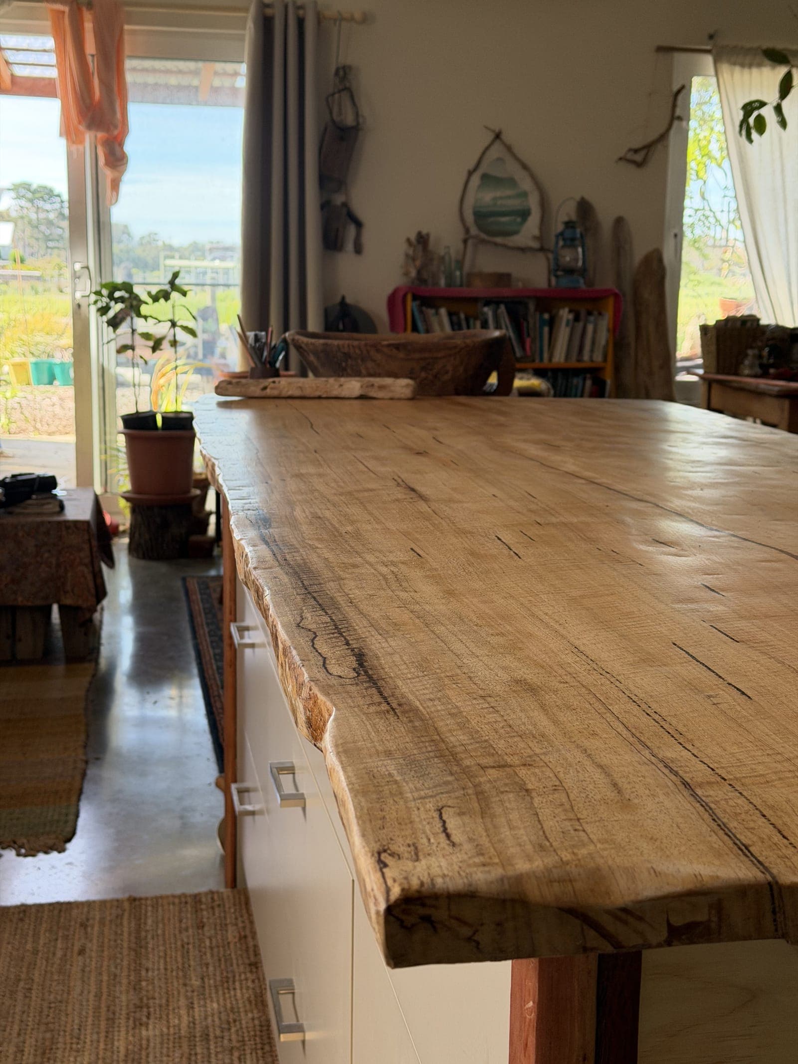 Close-up of a live-edge timber benchtop on a kitchen island